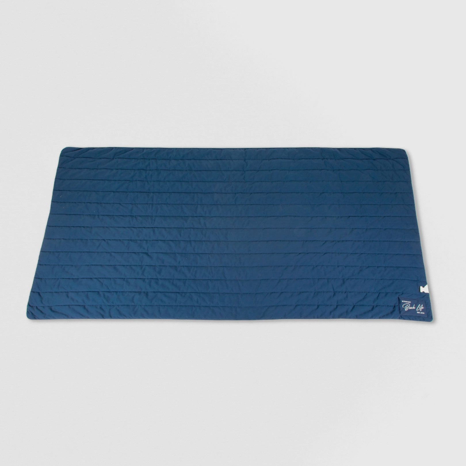 Blue quilted mat with a brand logo on a light gray background