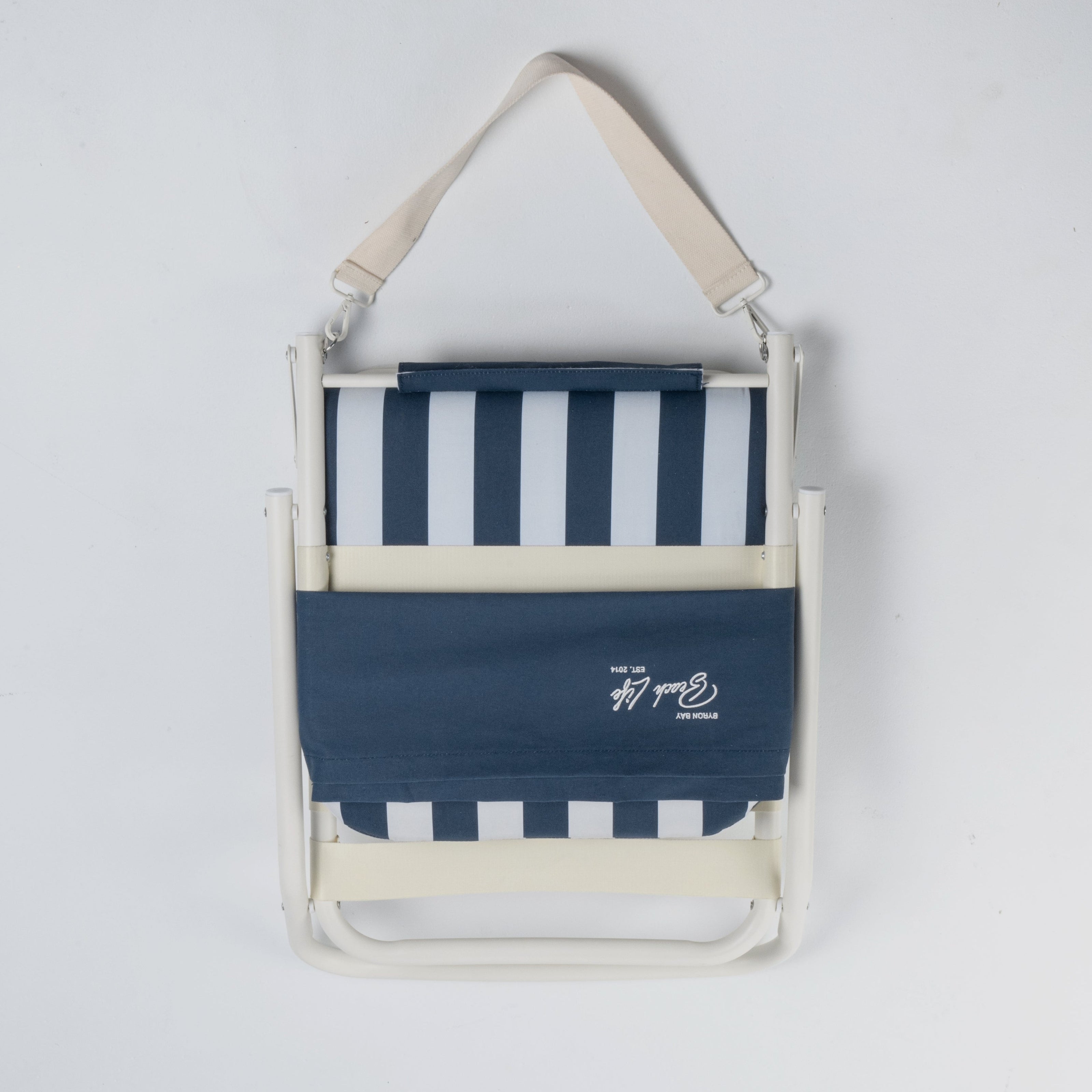 Foldable beach chair with blue and white striped design on a light gray background