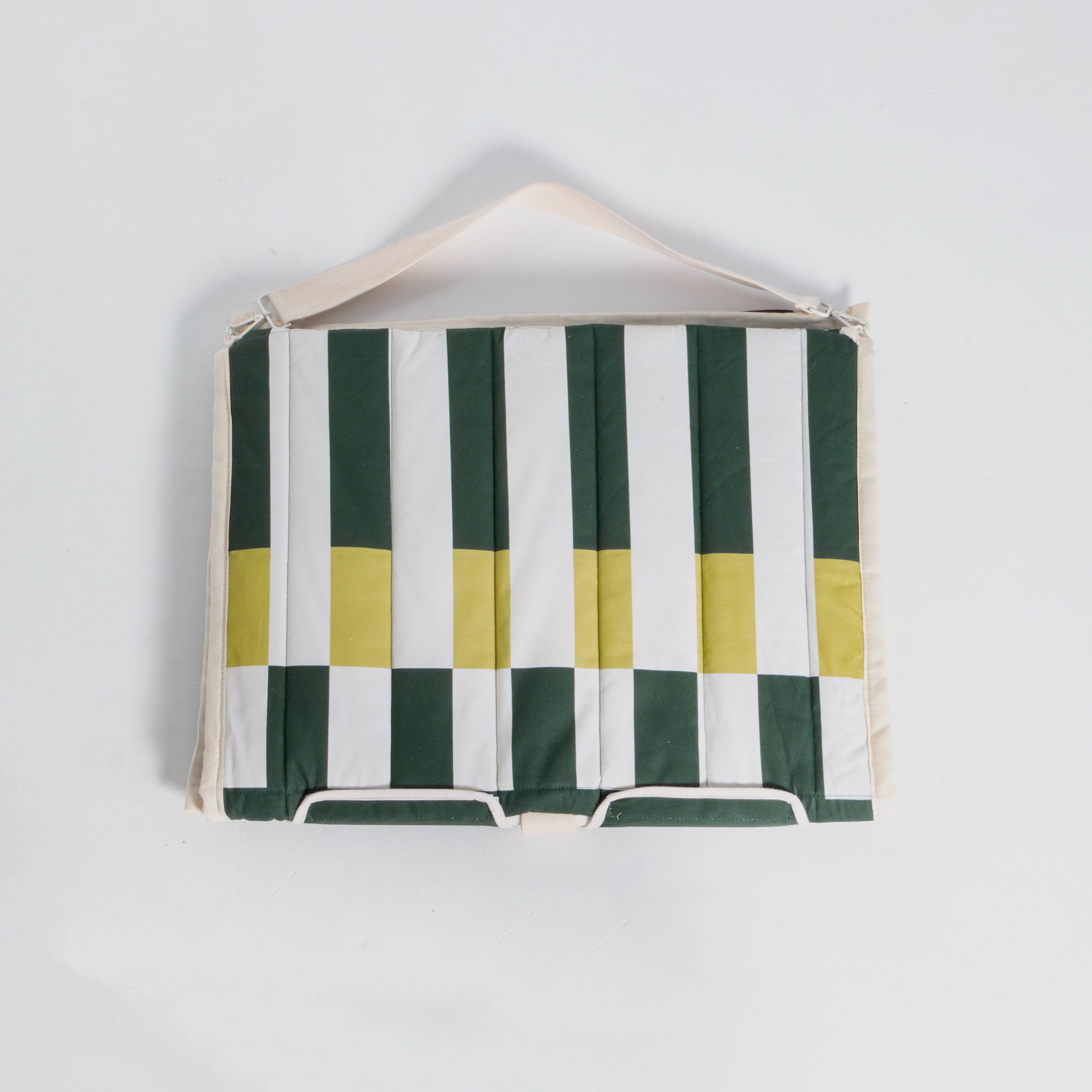 Green and white striped beach chair with yellow accents on a white background