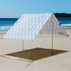 Beach Tent set up on Beach with bright sun shining on Beach Shelter on sand